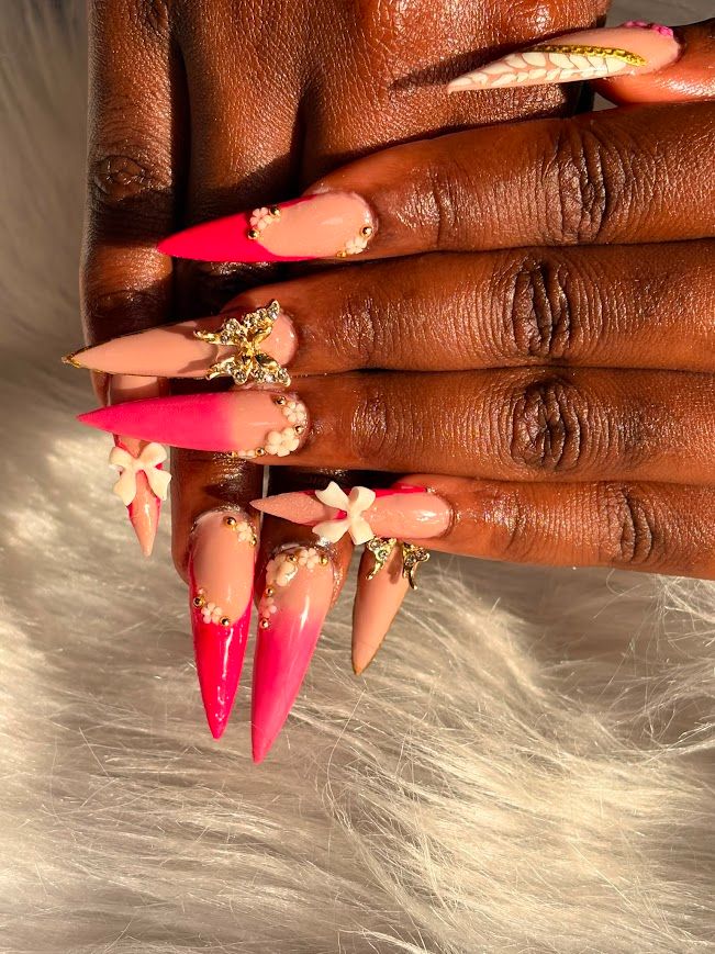 Pose Américaine Gel X stiletto nude et rose fluo ombré avec perles, noeuds et papillon dorés